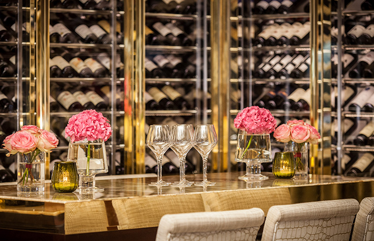 View of the laid sommelier's table in Restaurant Haerlin*** in front of the glass wall with stored wines